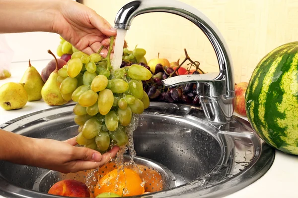 Hands washing grapes