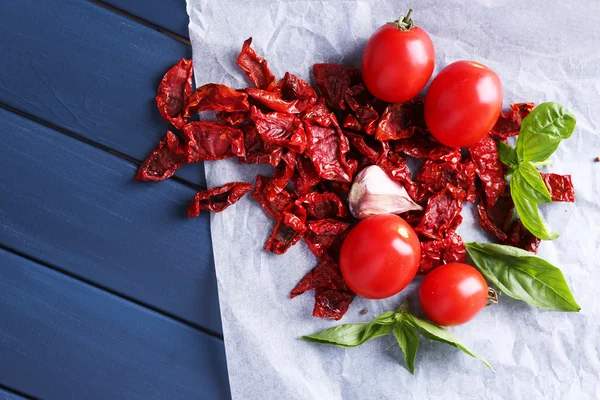 太阳晒干和新鲜的西红柿,罗勒叶,大蒜对彩色木