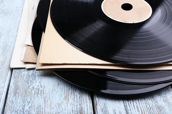 Vinyl records records and paper covers on wooden background