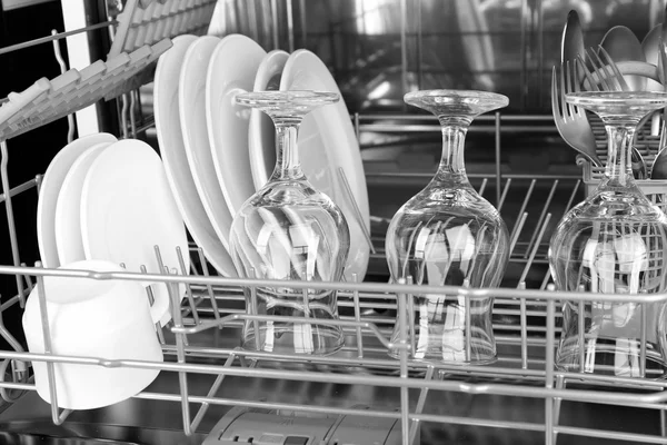 Open dishwasher with clean utensils in it