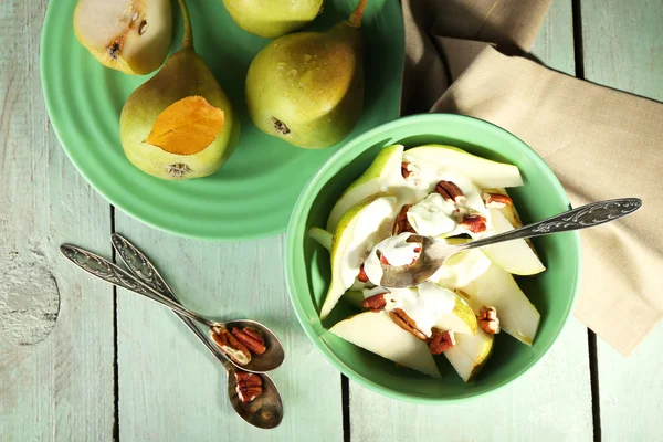 Tasty dessert with pears and fresh pears, on wooden table
