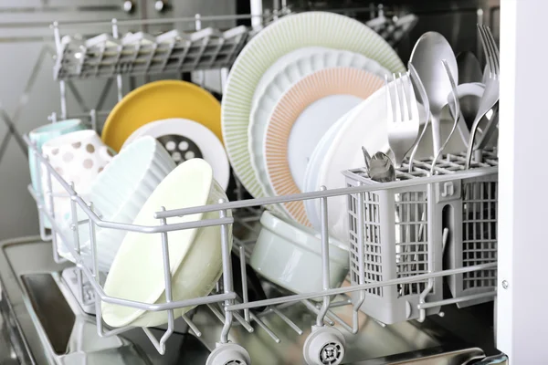 Open dishwasher with clean utensils in it