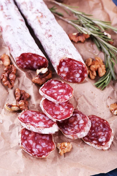French salami and walnuts on craft paper background