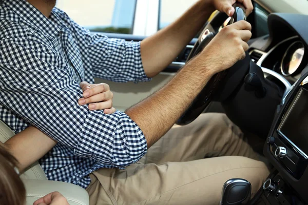 Loving couple holding hands in car close-up