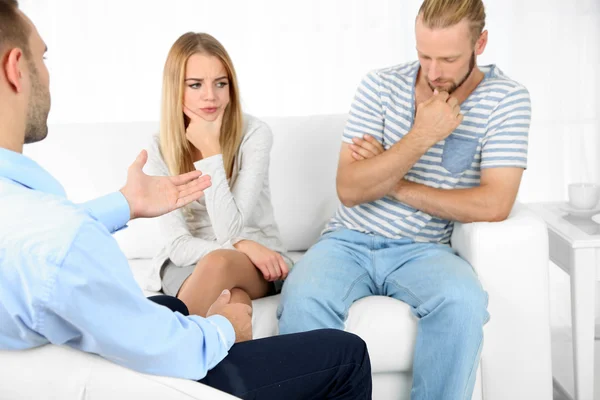 Unhappy couple not talking on couch at therapy session