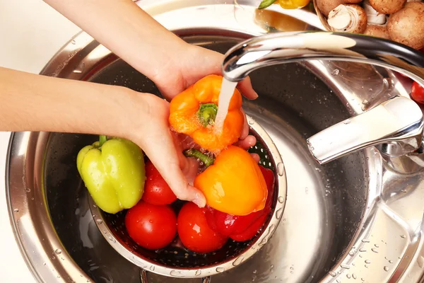 Woman\'s hands washing vegetables