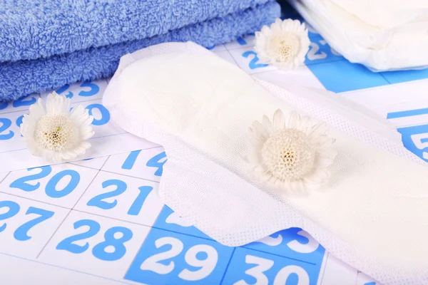 Sanitary pads, white flowers and towel