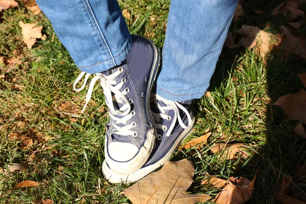 Feet in sneakers on grass