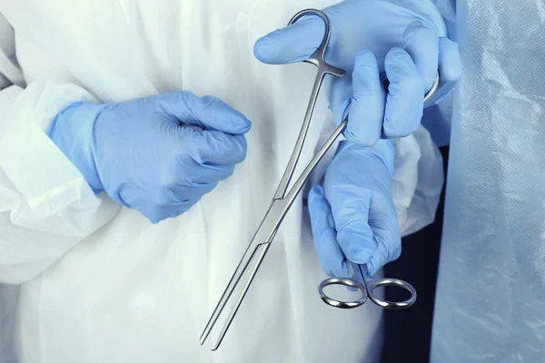 Surgeon\'s hands holding medical instrument