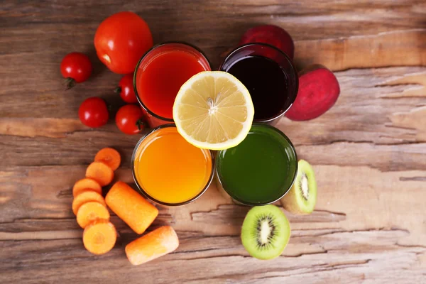 Fruit and vegetable juice in glasses and fresh fruits and vegetables