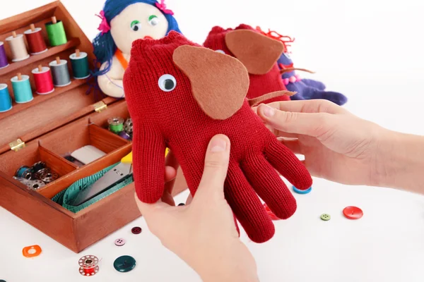 Making of handmade toys from gloves on white background