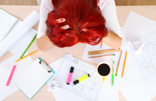 Tired woman over project on table