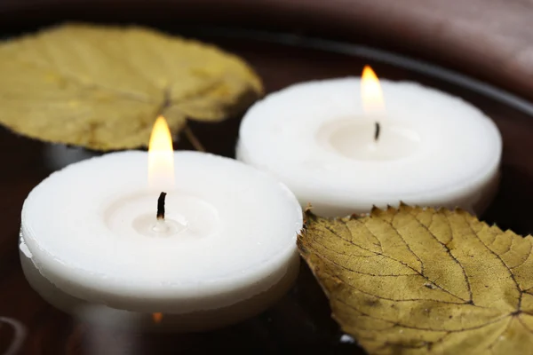 White candles floating in water