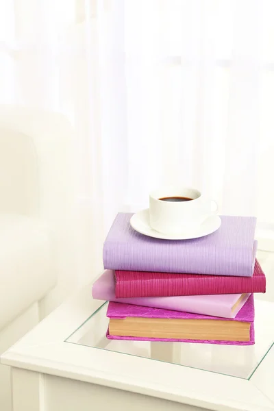 Pile of books with cup