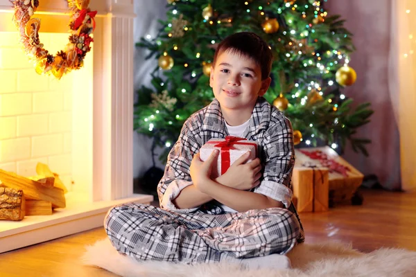 Little boy sitting near fireplace in room