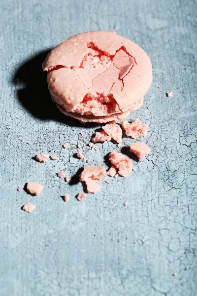 Bright tasty broken macaroon cake on old wooden background