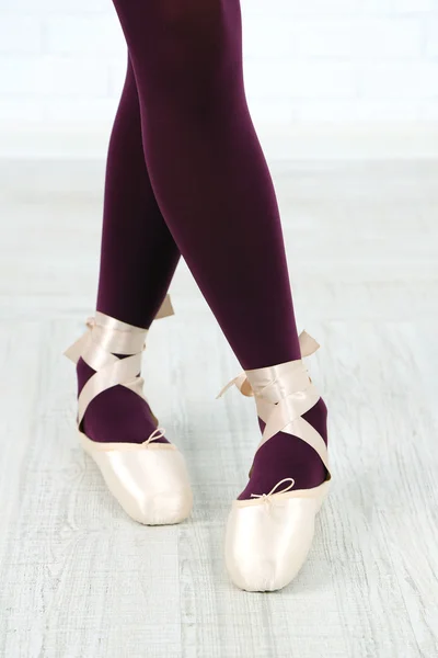 Ballerina in pointe shoes in dance hall