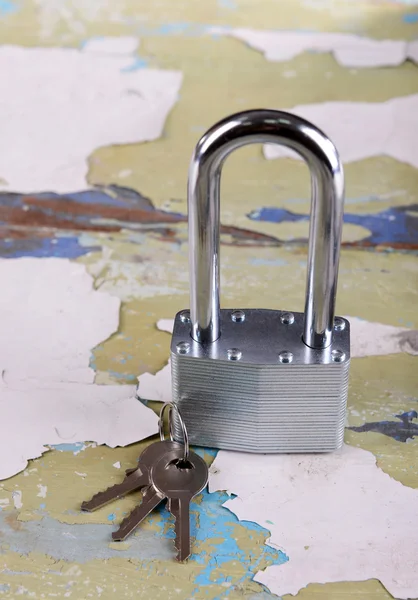 Padlock with keys on wooden background