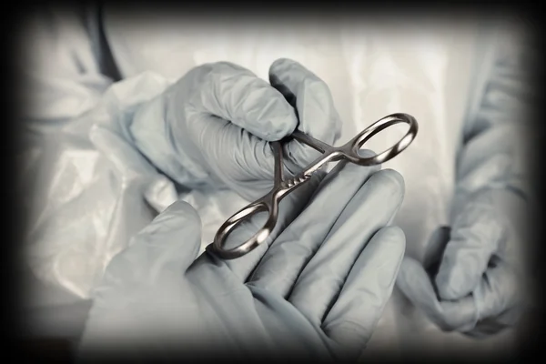 Surgeon\'s hands holding medical instrument