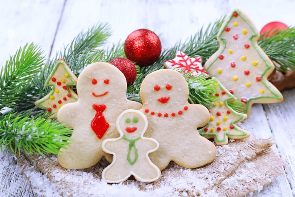 Gingerbread cookies with Christmas decoration on color wooden table background