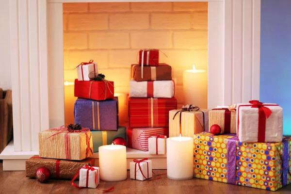 Christmas present boxes under fireplace on wooden floor, indoors