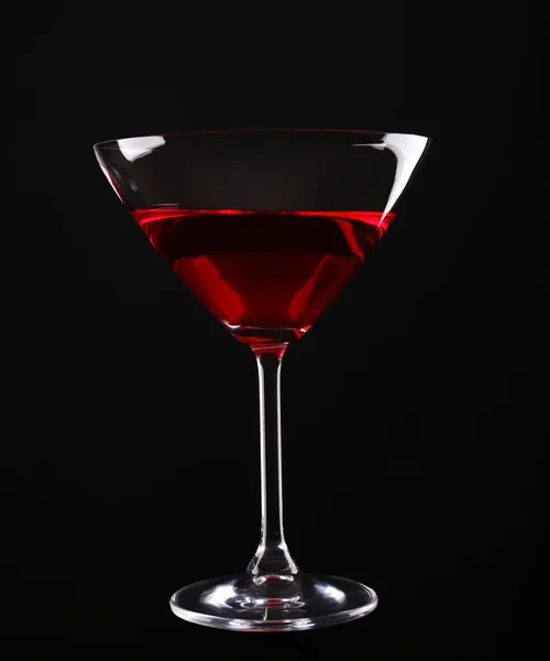 Colorful alcoholic beverage in glass on dark background