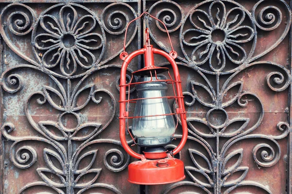 Kerosene lamp on wrought iron gates background