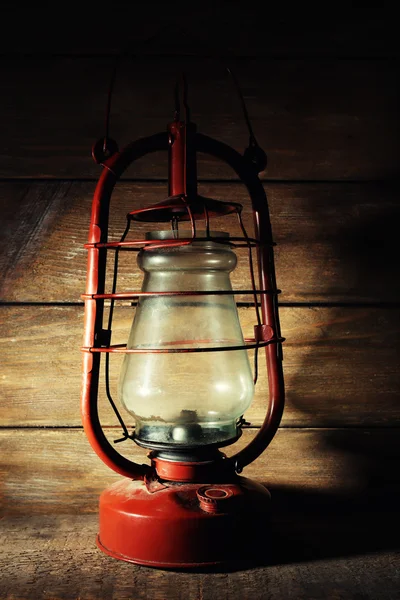 Kerosene lamp on wooden planks background