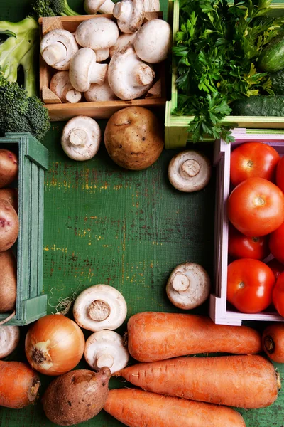 Different vegetables in boxes on wooden background top view