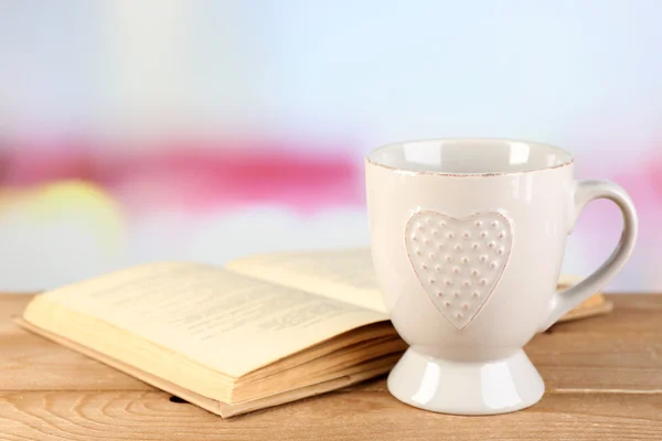 Cup and book on table