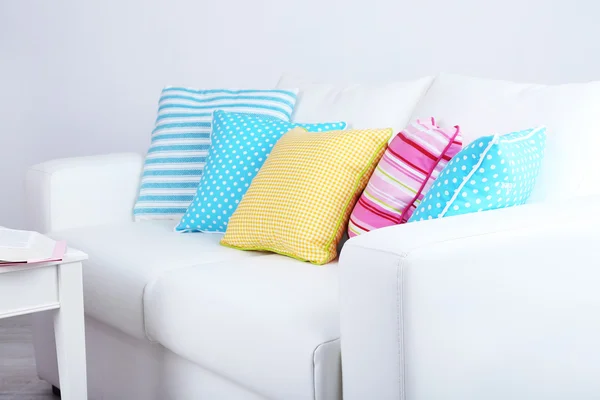 White sofa with colorful pillows in room