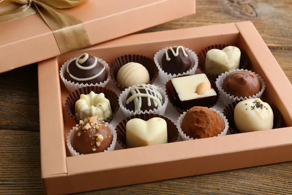 Delicious chocolate candies in gift box on table close-up