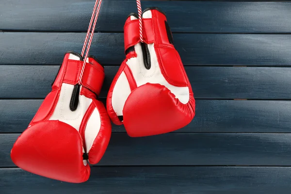 Pair of boxing gloves on color wooden background