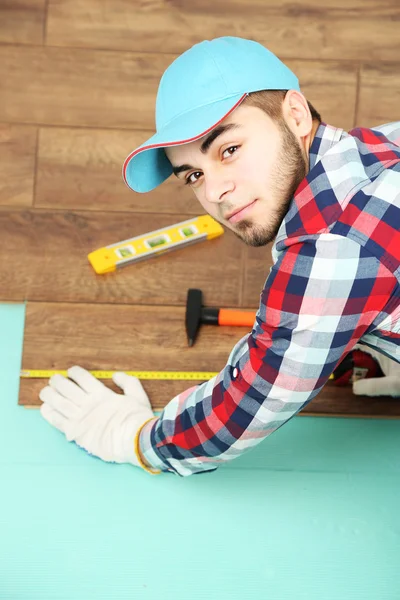 Carpenter worker installing laminate flooring