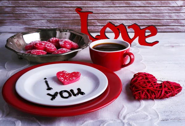 Cookie in form of heart on plate with inscription I Love You on color wooden table background