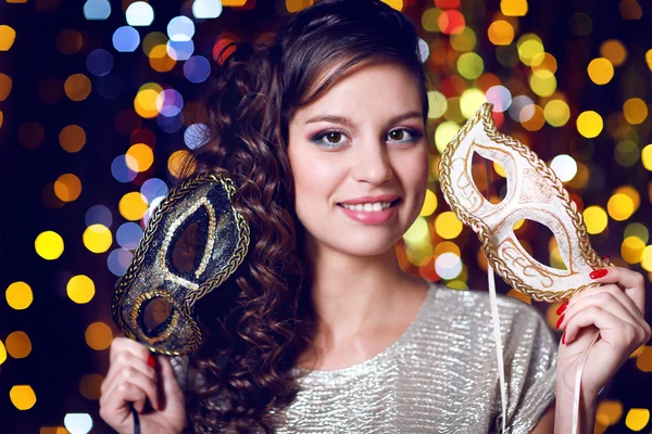 Beautiful girl with masquerade mask on bright background