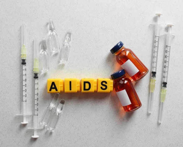 Aids word and medical equipment on light background