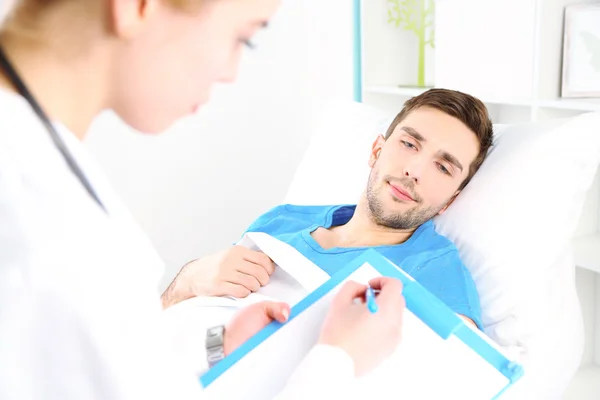 Doctor filling medical report for her patient close up