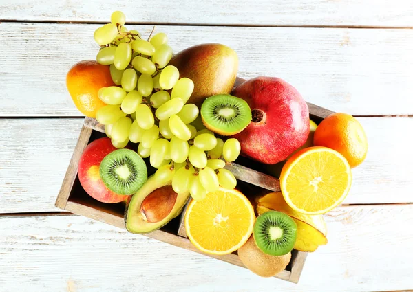 Assortment of fruits in box on wooden table