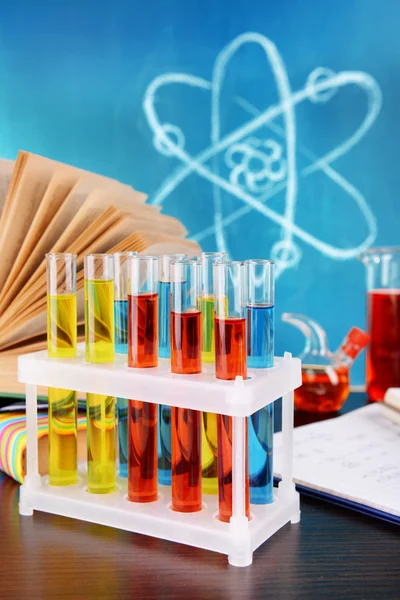 Glassware with chemical agent on desk, on green blackboard background