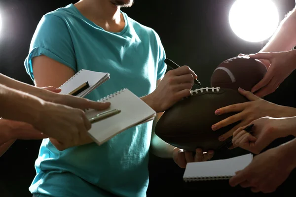 Autographs by American football star on black and lights background