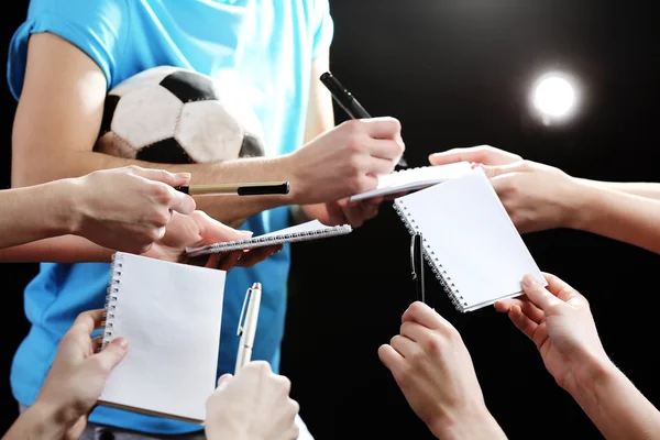 Autographs by football star on black and lights background