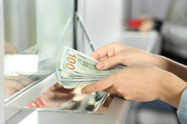 Female hand with money in cash department window. Currency exchange concept