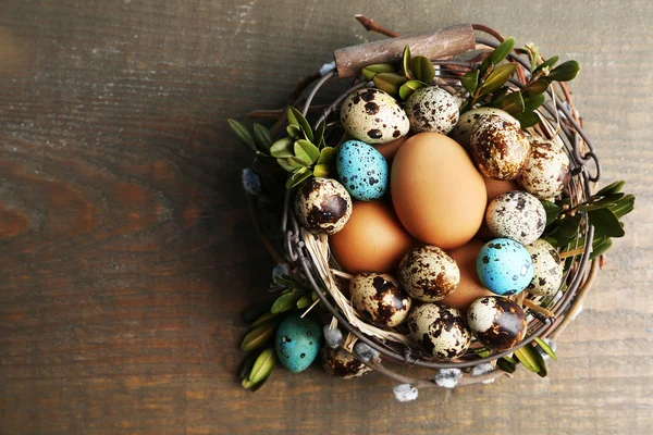 Bird eggs in wicker basket on  wooden background