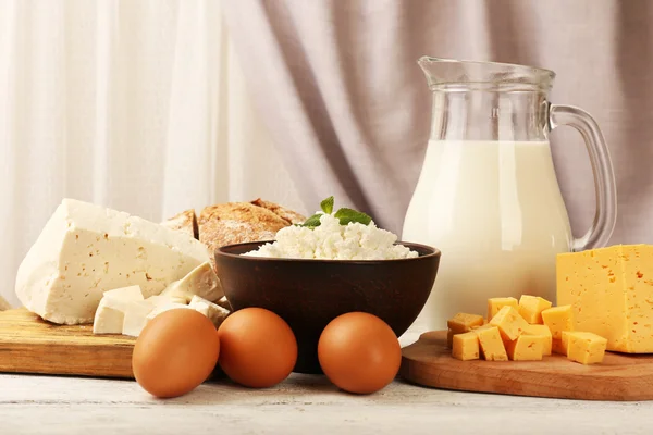 Tasty dairy products with bread on table on fabric background