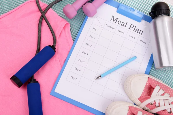 Meal plan and sports equipment top view close-up