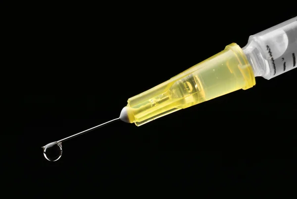 Medical syringe on black background