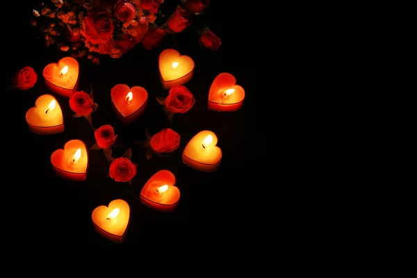 Romantic atmosphere with candle lights and flowers on dark background