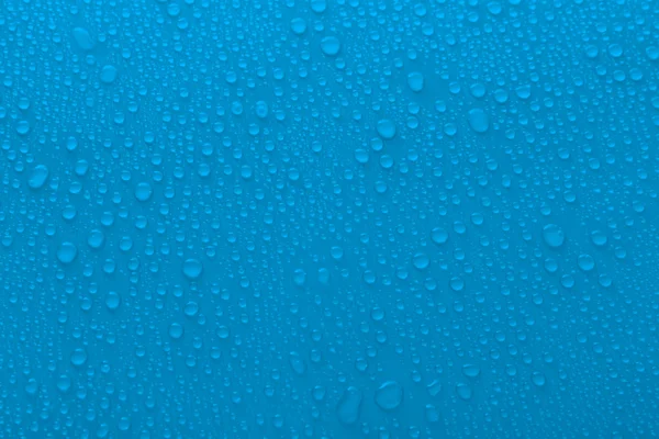 Water drops on glass on light background