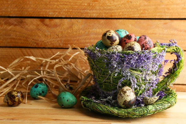 Bird colorful eggs in decorative mug on light background